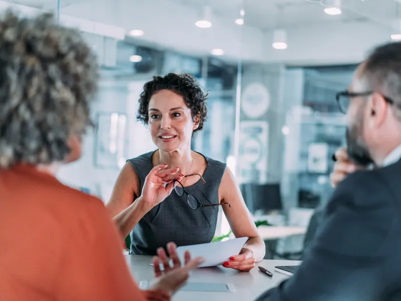 A professional financial services executive meets with peers at office.